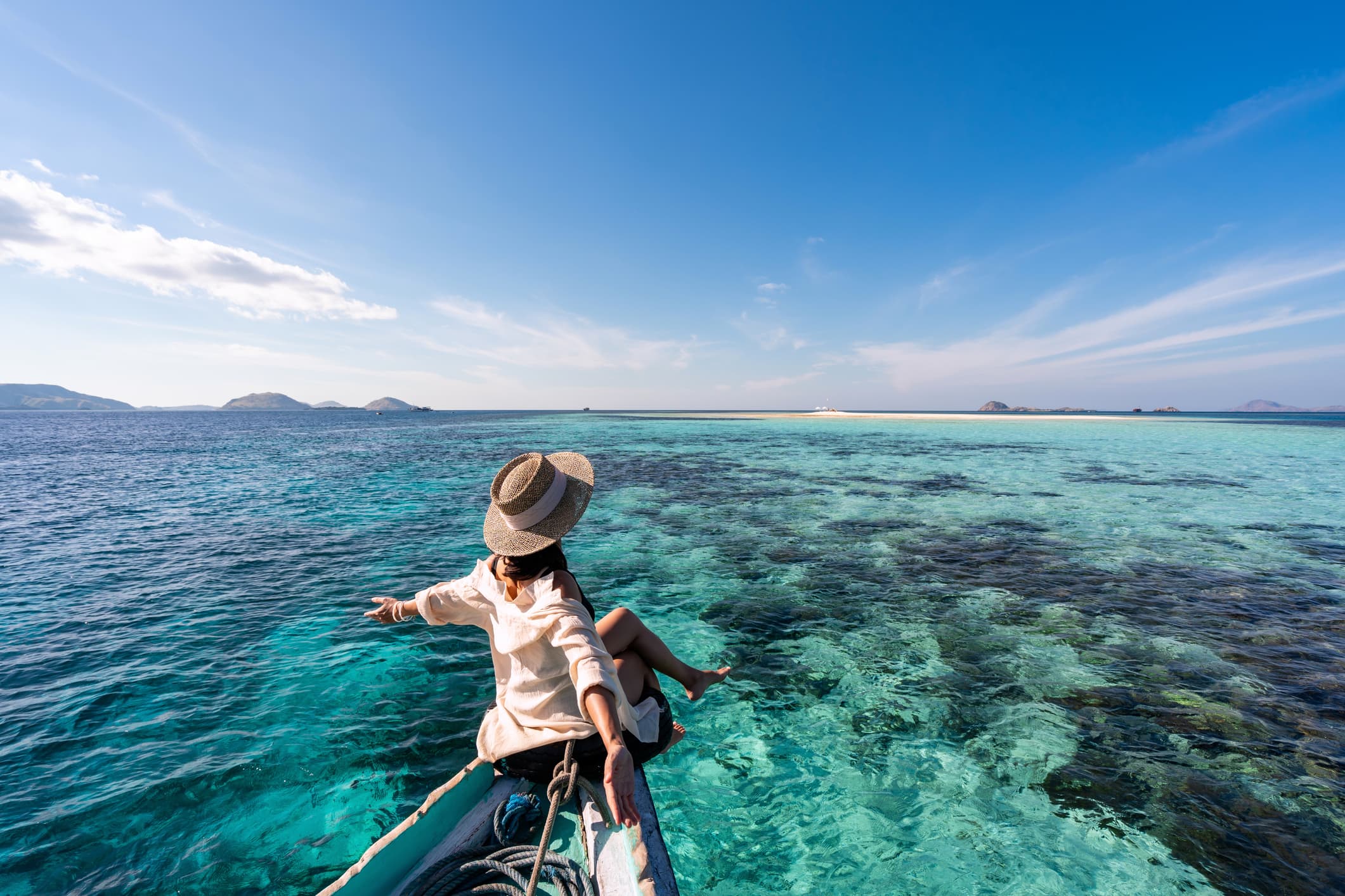 Traveller relaxing on a boat over crystal-clear water
